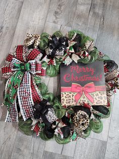 a christmas wreath on the floor with a sign that says merry christmas and leopard print