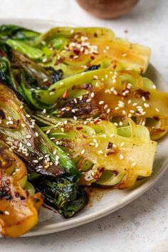 a white plate topped with broccoli covered in sesame seeds