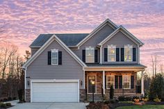 a large house with lots of windows and shutters on the front door at sunset