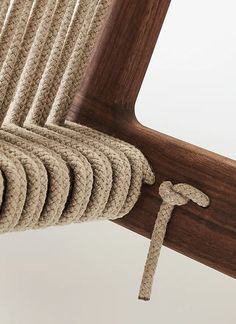 a close up of a rope on the side of a chair with a wooden frame