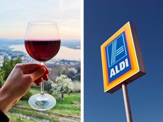 a hand holding a glass of wine next to a sign with the aldi logo