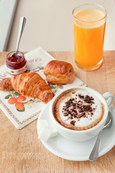 there is a cup of coffee and croissants on the table