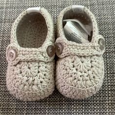 a pair of crocheted baby shoes sitting on top of a carpet