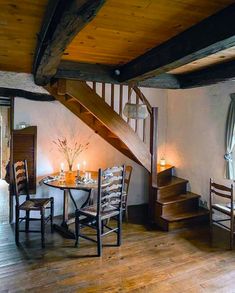 a wooden table sitting under a stair case