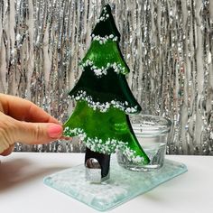 a green glass christmas tree sitting on top of a table