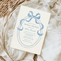 a blue and white bridal shower card on top of a bed next to wicker baskets