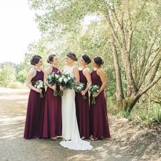 a group of women standing next to each other in front of trees and dirt ground