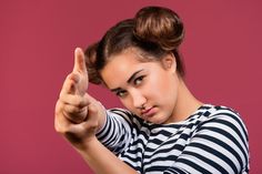 a woman in striped shirt pointing at something