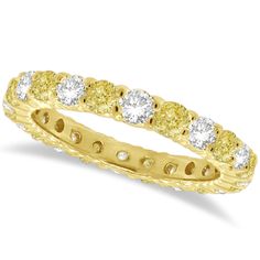 a yellow and white diamond ring with five stones in the center, set on a gold band