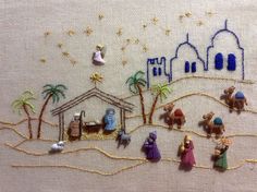 the nativity scene is embroidered onto a piece of fabric with gold thread on it