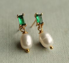 These great emerald green Art Deco earrings feature a beautiful and classic ivory freshwater pearl.   The earrings measure 23mm (just under an inch) in length and have gold plated ear posts.  The freshwater pearl is designed to hang just below the earlobe.   This piece of jewellery comes packaged in a nice recycled gift box with a handmade tag, all ready to give or keep. 🖤 FASTER SHIPPING 🖤 Need this fast? We offer a Faster Shipping option here: https://www.etsy.com/uk/listing/100107311/faster Elegant Green Pearl Earrings For Pierced Ears, Elegant Pear-shaped Emerald Earrings, Classic Green Pearl Drop Jewelry, Green Dangle Pearl Earrings For Anniversary, Green Pearl Drop Earrings For Anniversary, Elegant Green Pearl Earrings Gift, Green Pearl Earrings For Anniversary, Green Drop Pearl Earrings For Wedding, Green Pearl Drop Earrings For May Birthstone