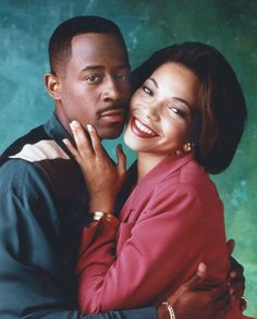 a man and woman hugging each other in front of a green wall with blue background