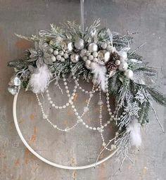 a christmas wreath hanging on the side of a building with white and silver decorations around it