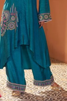 Teal asymmetric kurta with geometric placement embroidery using resham, dori, sequins and beads. Paired with a palazzo with embroidered hem. - Aza Fashions Asymmetric Kurta, Kurta With Palazzo, Placement Embroidery, Embroidered Hem, Women Kurta, Straight Kurta, Silk Embroidery, Full Sleeves, Aza Fashion