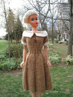 a doll is standing in the grass wearing a dress