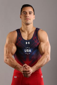 a man posing for a photo with his hands on his hips and wearing red shorts