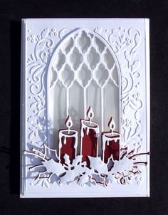 a card with candles on it in front of a window