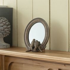 a mirror sitting on top of a wooden dresser