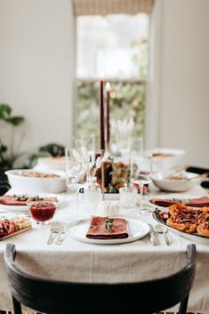 a table set with plates, glasses and candles for a dinner party or special occasion