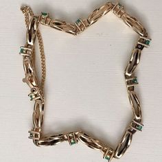 "Exquisite 14 karat yellow gold bracelet set with 11 round-cut emeralds on a figure 8 chain. Each emerald measures approximately 2.64 millimeters in diameter and weighs an estimated 0.08 carats. The bracelet is 6 1/2\" long and weighs 9.7 grams. It terminates in a safety clasp with safety chain, and is marked 14K. Excellent estate condition. We are listing several pieces of estate jewelry, along with other items fresh from fine North Carolina estates. We are happy to combine shipping. Thank you 14k Gold Bracelet For Formal Occasions With May Birthstone, Formal 14k Gold Bracelet With May Birthstone, Formal Gold Bracelet With May Birthstone, Green Jubilee Gold Bracelet For Formal Occasions, Formal Green Gold Jubilee Bracelet, Classic Gold Bracelets With Emerald, Classic 14k Gold Green Bracelet, 14k Gold Green Jubilee Bracelet, Classic Green 14k Gold Bracelet