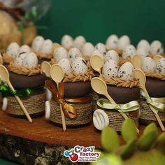 there are many small baskets with spoons and eggs in them on top of the table