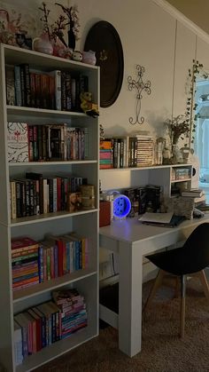 a room with a desk, bookshelf and chair in it next to a window