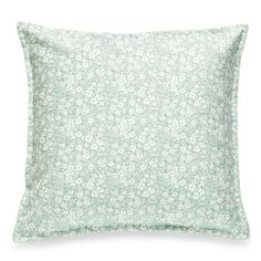 a green pillow with white flowers on it