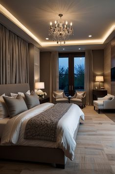 a large bed sitting in the middle of a bedroom next to two chairs and a chandelier