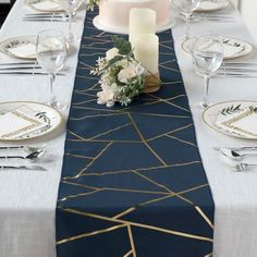 the table is set with white and gold place settings