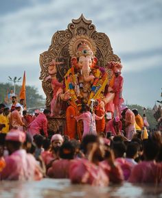 an idol is displayed in front of a large group of people sitting on the ground