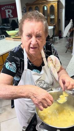 an older woman stirring food in a pot