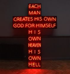 a lighted cross with the words, each man creates his own god for himself he's own hell