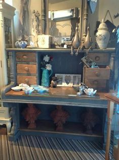 an old dresser has been decorated with blue and white decor, including vases and other items