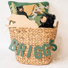 a stuffed bear sitting in a basket with the word spring spelled out on it's side