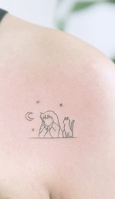 the back of a woman's shoulder with a cat and dog tattoo on it