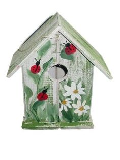 a birdhouse with ladybugs and daisies painted on it