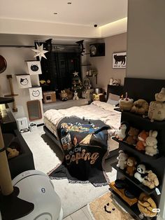 a room filled with lots of stuffed animals on shelves next to a bed covered in a blanket