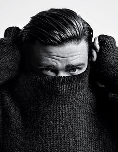 a man covering his face with a sweater