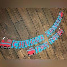 a birthday banner that says happy birthday and two tow trucks hanging on a wood floor