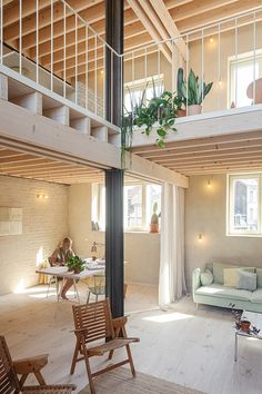 a living room filled with lots of furniture next to a tall wooden ceiling mounted high in the air