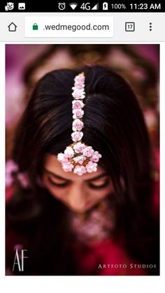 a woman wearing a head piece with flowers on it