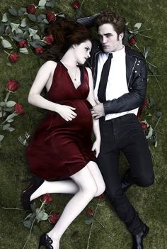 a man and woman laying on the ground next to each other in front of roses