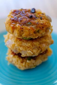 two crab cakes stacked on top of each other on a blue plate with white background