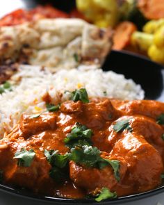 a close up of a plate of food with rice and meat in sauce on it