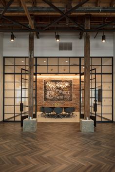 an empty meeting room with wooden floors and exposed ceilings