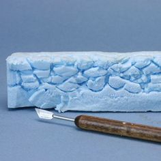 a blue block of ice with a wooden handle