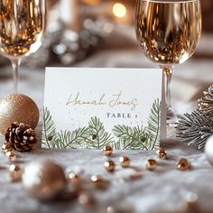 there is a place card next to two wine glasses on the table with christmas decorations