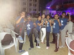 a group of people standing next to each other in front of a building at night