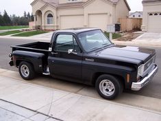 a black pickup truck parked in front of a house