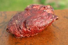 a piece of meat sitting on top of a wooden table